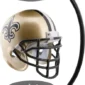 A miniature gold football helmet with black fleur-de-lis design is levitating between two black magnetic stands.
