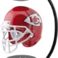 A red football helmet with a white arrowhead logo featuring the letters "KC" is levitating between two magnetic bases connected by a black curved arm.