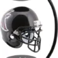 A black football helmet with a team logo is suspended between two magnetic bases in a levitating display stand.