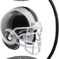 A black and white football helmet is suspended between two black magnetic bases, creating a levitating effect.