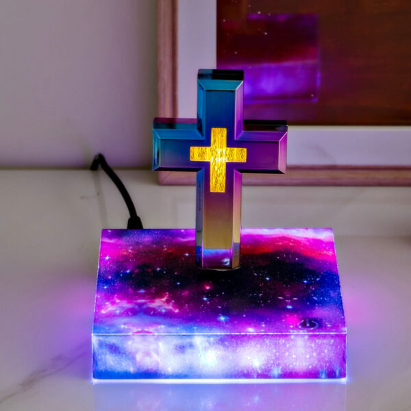 4-levitating cross nightlight with starry base The Floating Cross Nightlight, with its multicolor lights and Greek cross design, sits elegantly on a galaxy-patterned base on a marble surface.
