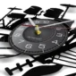 A wall clock with a drum kit design, featuring bold white numerals on a black background, and drum silhouette details.