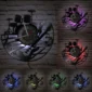 Wall clock with a musical instrument design, featuring a black silhouette of drums and guitars, illuminated by colorful LED lights, set against a brick background.