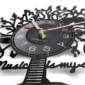 Close-up of a clock with a black vinyl record design. The clock face has white numerals, and stylized cutouts form a tree and the text "music" at the base.