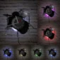 Wall clocks shaped like drum sets with neon lights in various colors, mounted on a brick wall.