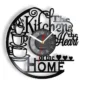 Wall clock with a design featuring stacked coffee cups and the phrase "The Kitchen is the Heart of the Home" in decorative black lettering.