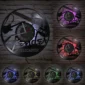 A wall clock shaped like a vinyl record with Fender Telecaster design features various colored LED lights, displayed on a brick wall.