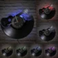 Vinyl record wall clocks in the shape of a guitar with musical notes, shown in different colored lights: blue, red, yellow, green, and multicolor, against a brick wall.