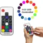 A hand holds an RF wireless remote for an RGB LED controller, featuring various color buttons and settings. A color palette is shown on the right.