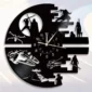 Wall clock with sci-fi figures and vehicle silhouettes carved into a black circular design, displaying time with white numbers and hands.