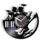 Wall clock with musical instrument design featuring drums, keyboard, and guitar silhouettes in black.