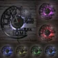 Wall clock with cups and the phrase "The Kitchen is the Heart of the Home," illuminated in various colors including purple, red, green, yellow, and blue.