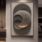 A framed artwork features layered, textured circular shapes with a perforated design, creating a three-dimensional effect on a wall.