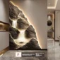 A modern interior with a large illuminated wall art depicting flowing waterfalls over rocks. A tiny boat is at the base. Text at the bottom reads: "Flowing water symbolizes continuous wealth.